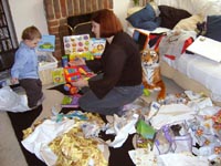 Mummy helps Tom unwrap his Xmas presents